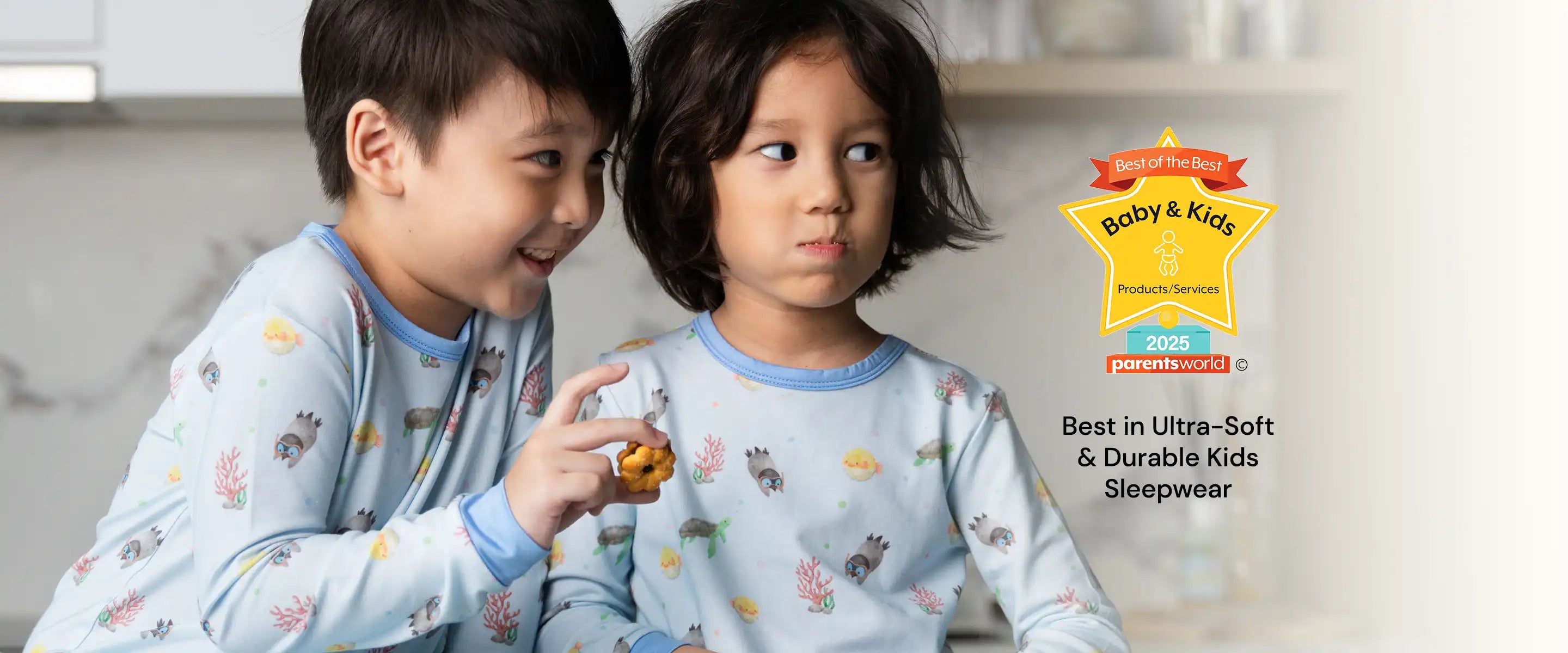 Two children wearing matching blue pajamas with Parents World Magazine Award 2025 Winner for Best in Ultra-Soft & Durable Kids Sleepwear